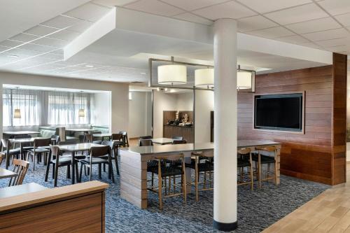 a dining room with tables and chairs and a flat screen tv at Fairfield Inn & Suites by Marriott Wentzville in Wentzville