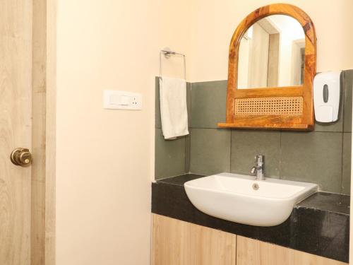 a bathroom with a sink and a mirror at Hotel Tattva Suites in Pune