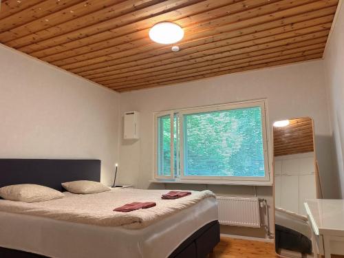 una camera da letto con un letto grande e una finestra di Natural Cottage a Kauniainen