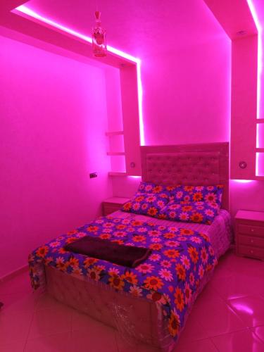 a bedroom with a bed with purple lights at Hay Salam Agadir in Agadir