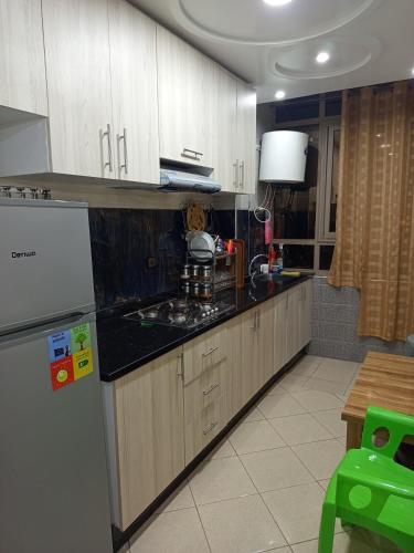 a kitchen with wooden cabinets and a refrigerator at Hay Salam Agadir in Agadir