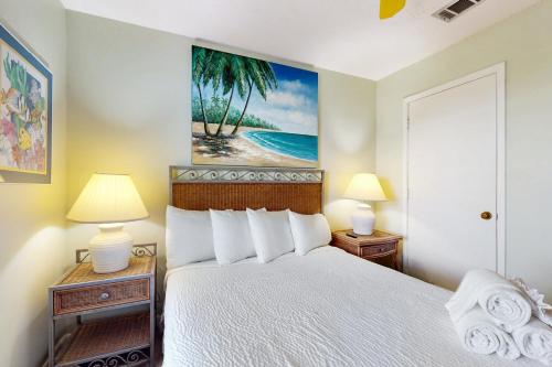 a bedroom with a bed with two lamps and a painting at Poolside Villas 306 in Destin