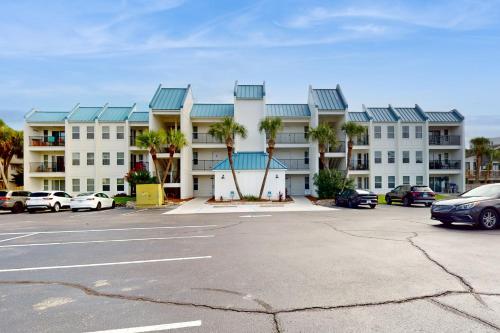 a large apartment building with palm trees in a parking lot at Poolside Villas 306 in Destin