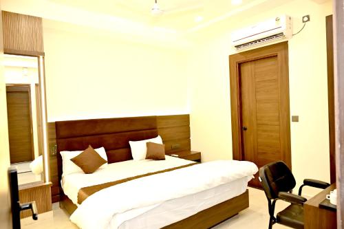 a bedroom with a bed and a desk and a chair at JMD Royal Residency I Luxury 3-Star Hotel in Varanasi