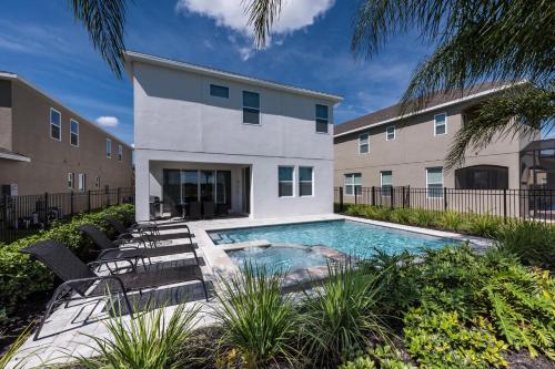 a swimming pool in front of a building at Modern Home Near Disney With Private Pool, Media Room And Waterpark & Resort Access At Encore Resorts Reunion - 7576Mr in Kissimmee