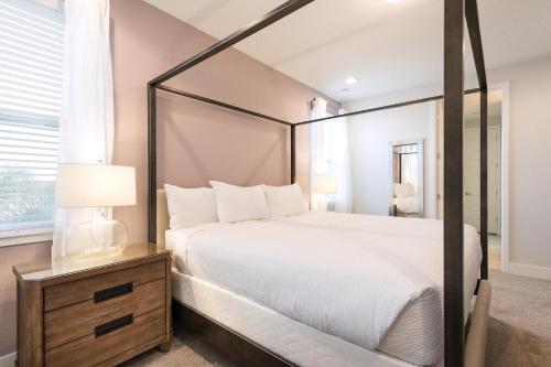 a bedroom with a large white bed and a mirror at Modern Home Near Disney With Private Pool, Media Room And Waterpark & Resort Access At Encore Resorts Reunion - 7576Mr in Kissimmee