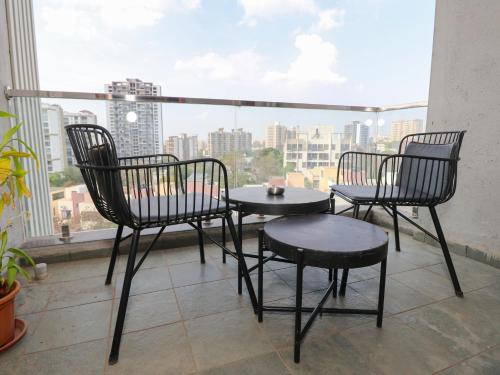 three chairs and a table on a balcony with a view at Hotel Tattva Suites in Pune