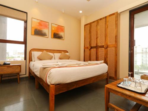 a bedroom with a large bed and a table at Hotel Tattva Suites in Pune