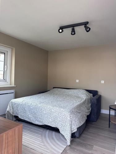 a bedroom with a bed with a black shelf on the wall at La Petite Hortense in Conteville