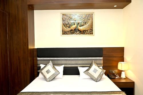 a bedroom with a bed with a poster on the wall at JMD Royal Residency I Luxury 3-Star Hotel in Varanasi