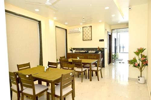 a dining room with wooden tables and chairs at JMD Royal Residency I Luxury 3-Star Hotel in Varanasi
