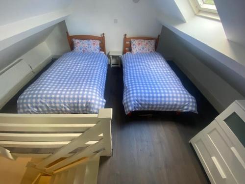 two twin beds in a room with at Horseshoe Cottage, Killarney in Killarney