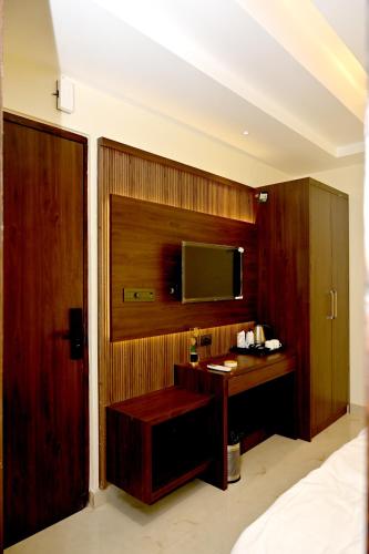 a bedroom with a desk and a tv on a wall at JMD Royal Residency I Luxury 3-Star Hotel in Varanasi