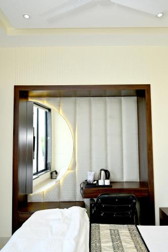 a bedroom with a mirror and a bed and a desk at JMD Royal Residency I Luxury 3-Star Hotel in Varanasi