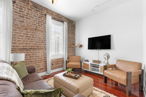 a living room with a brick wall at Downtown Loft- Steps away from Plant Riverside! in Savannah
