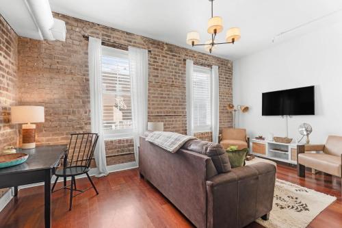 a living room with a couch and a table at Downtown Loft- Steps away from Plant Riverside! in Savannah