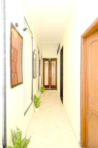a hallway of a house with plants and a door at JMD Royal Residency I Luxury 3-Star Hotel in Varanasi
