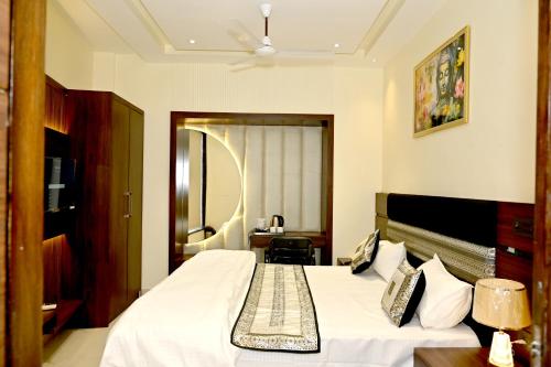a bedroom with a large bed with a white bedspread at JMD Royal Residency I Luxury 3-Star Hotel in Varanasi