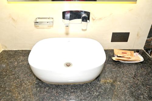 a white sink sitting on a counter in a bathroom at JMD Royal Residency I Luxury 3-Star Hotel in Varanasi