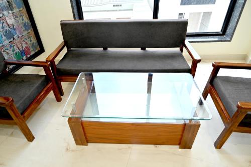 a living room with two chairs and a glass coffee table at JMD Royal Residency I Luxury 3-Star Hotel in Varanasi