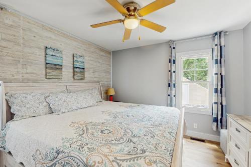 a bedroom with a bed and a ceiling fan at Beach Bungalow Getaway in Michigan City