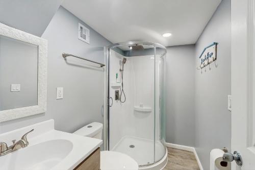 a bathroom with a shower and a toilet and a sink at Beach Bungalow Getaway in Michigan City