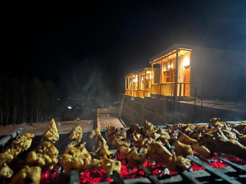 a bunch of chickens cooking on a grill at night at Yuligo Resort Skardu in Skardu