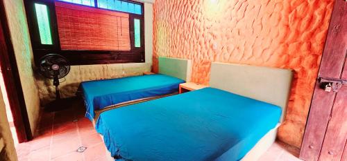 two beds sitting in a room with a window at Casa Campestre El Laurel in Estación El Salto