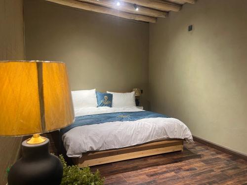 a bedroom with a bed and a lamp at Yuligo Resort Skardu in Skardu