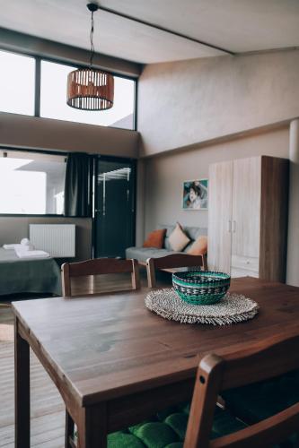 a dining room with a wooden table and a couch at Lofos Studio in Katsikás