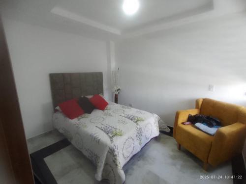 a bedroom with a bed and a chair at Espectacular apartamento acqua Hills in Dosquebradas