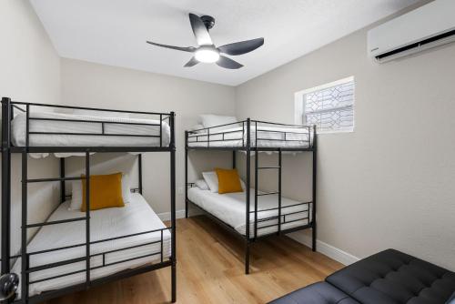 two bunk beds in a room with a ceiling fan at Stunning Tampa Stay - Prime Location & Comfort in Tampa