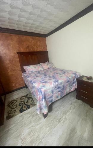 a small bedroom with a bed and a dresser at Perfect vibez in Portmore