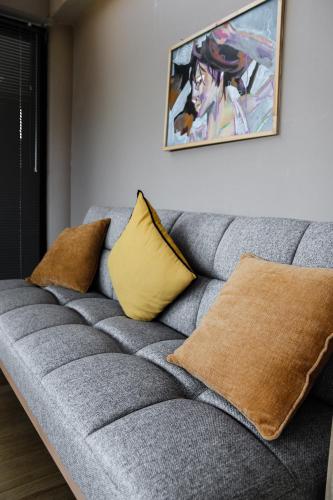 a gray couch with two pillows and a painting on the wall at Lofos Studio in Katsikás