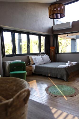 a bedroom with a bed and a chair and windows at Lofos Studio in Katsikás