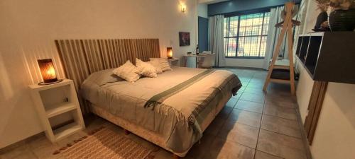 a bedroom with a bed with two lamps and a window at Planta Baja y Garage "Dido" Monoambiente Completo in La Cieneguita