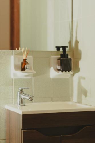 a bathroom sink with a soap dispenser on the wall at Cabecera House in Bucaramanga
