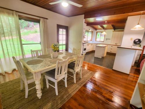 a kitchen and dining room with a table and chairs at Thrums Bush Retreat in Upper Orara