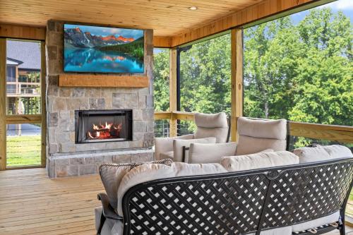 a screened porch with a fireplace and a tv at NEW Spacious Clarkson Getaway w Games & Yard in Clarkson