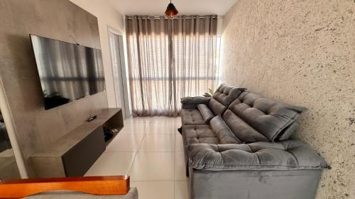 a living room with a couch and a television at Dona Olivia Universidade in Vitória da Conquista