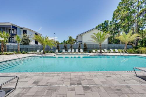 a swimming pool with chairs and a house at 2 Mi to Ocean Townhome with Pool and Dog Park in PCB! in Panama City Beach