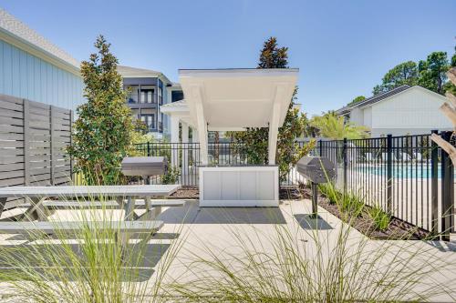 a patio with a white pergola in front of a fence at 2 Mi to Ocean Townhome with Pool and Dog Park in PCB! in Panama City Beach
