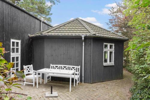 a black shed with two chairs and a bench in it at 1060-Thisted-Rodals-Bakke-21 in Torsted