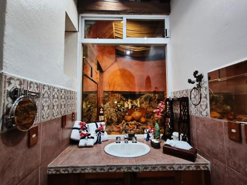 a bathroom with a sink and a window at Boutique Hotel Casa Cid de León in Oaxaca City