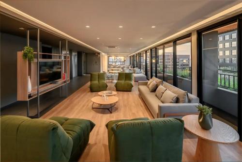 a large living room with couches and a tv at Novíssimo: Go Carlos Gomes - Infra estrutura e Vista Espetacular! in Porto Alegre