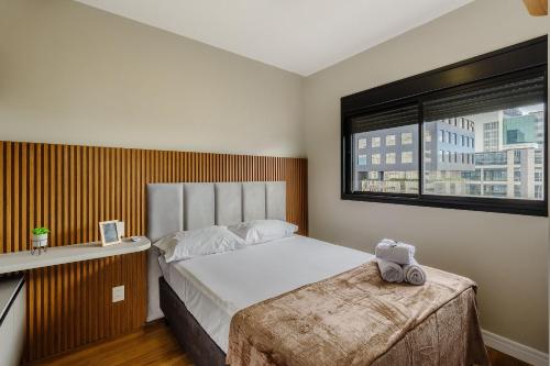 a bedroom with a large bed and a window at Novíssimo: Go Carlos Gomes - Infra estrutura e Vista Espetacular! in Porto Alegre