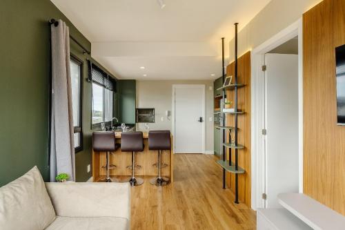 a living room with a couch and a kitchen at Novíssimo: Go Carlos Gomes - Infra estrutura e Vista Espetacular! in Porto Alegre