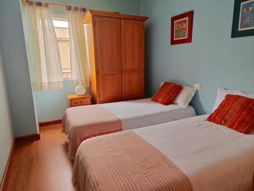 a bedroom with two beds and a cabinet at Casa Capi in La Orotava