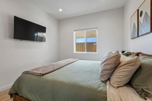 a bedroom with a bed and a flat screen tv at The Oaks, Stylish Luxury Stay, Fire Pit & Patio in Thousand Oaks