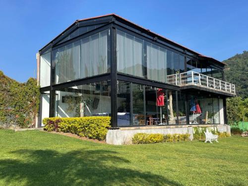 a large glass house with a lawn in front of it at Hotel Brisas Del Lago in Valle de Bravo